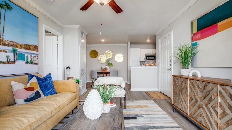 a living room with a couch, coffee table and fan at The Argyle