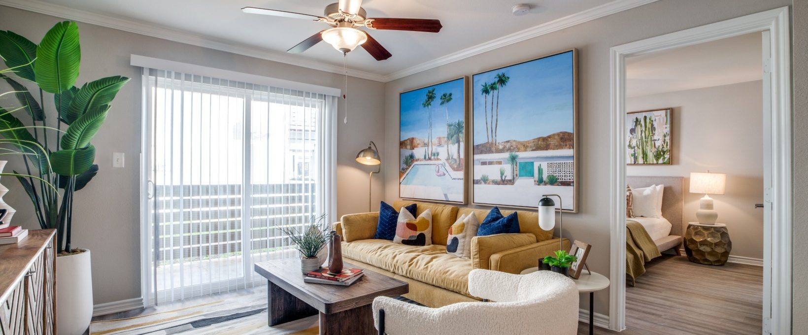 a living room with a ceiling fan and a large picture at The  Argyle