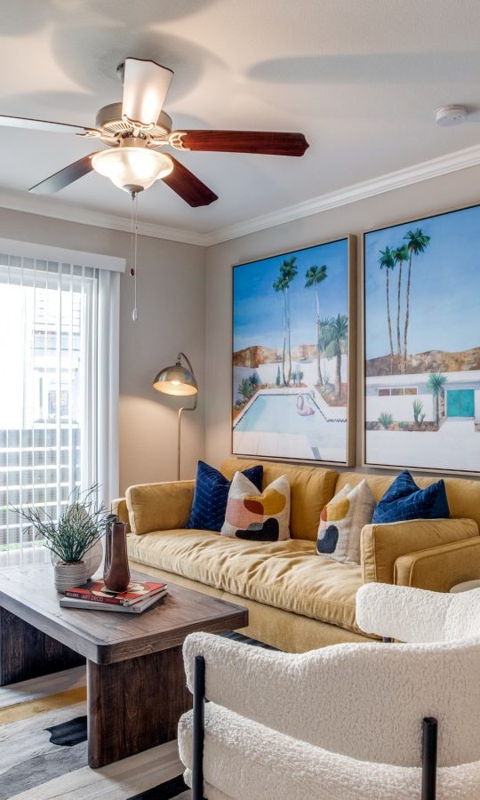 a living room with a ceiling fan and a large picture at The  Argyle