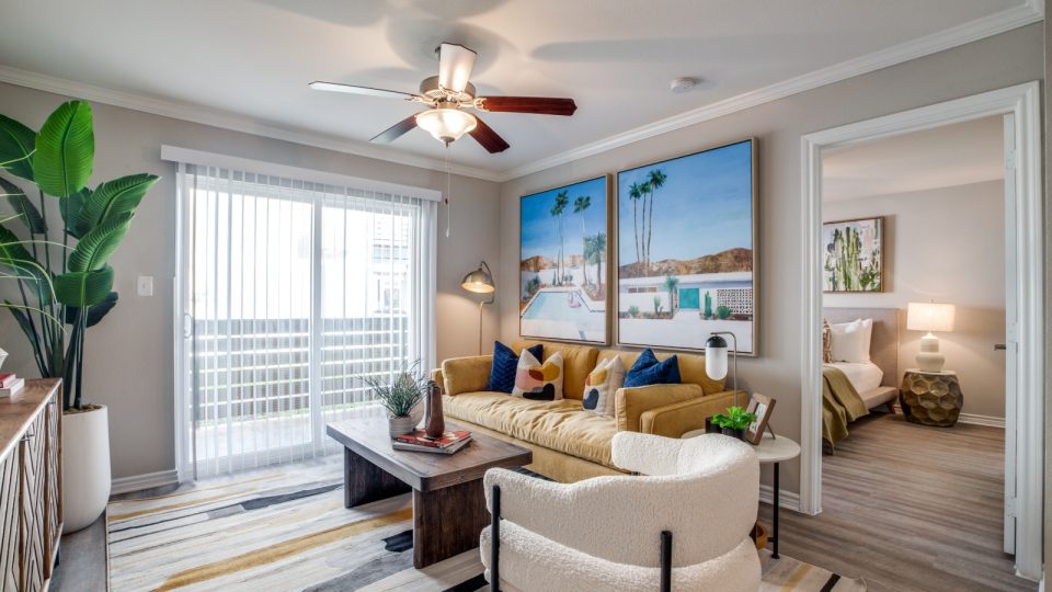 a living room with a ceiling fan and a large picture at The  Argyle